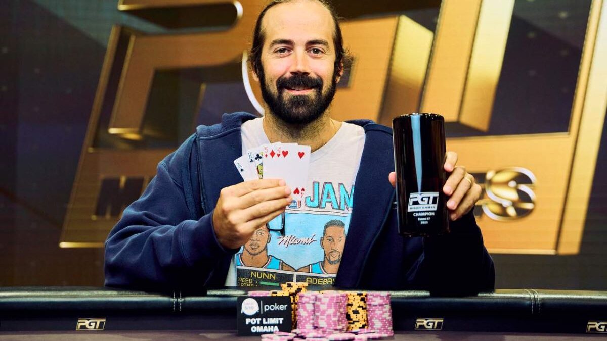 Il giocatore di poker felice mischia le carte di poker nel casinò